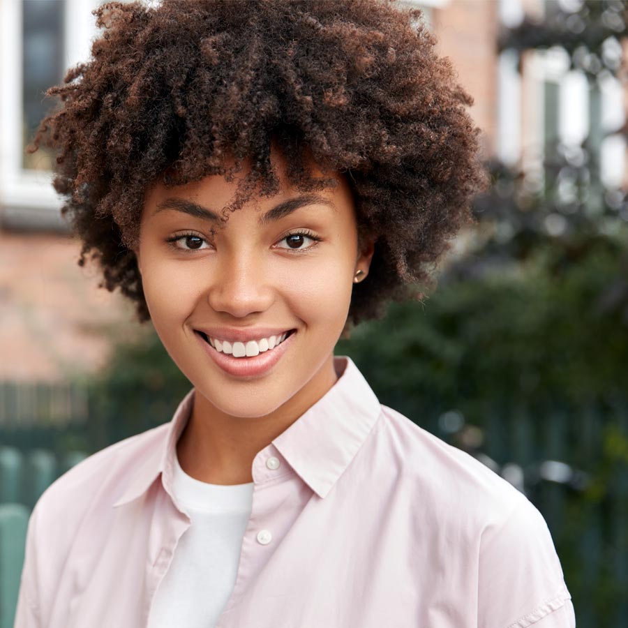 Happy woman standing outside, blurred background