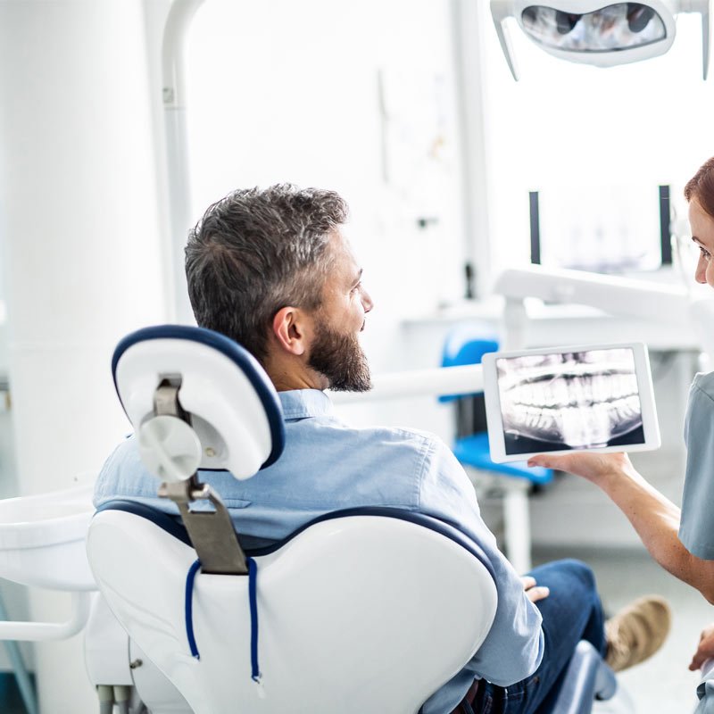 Dentist showing X-ray to patient